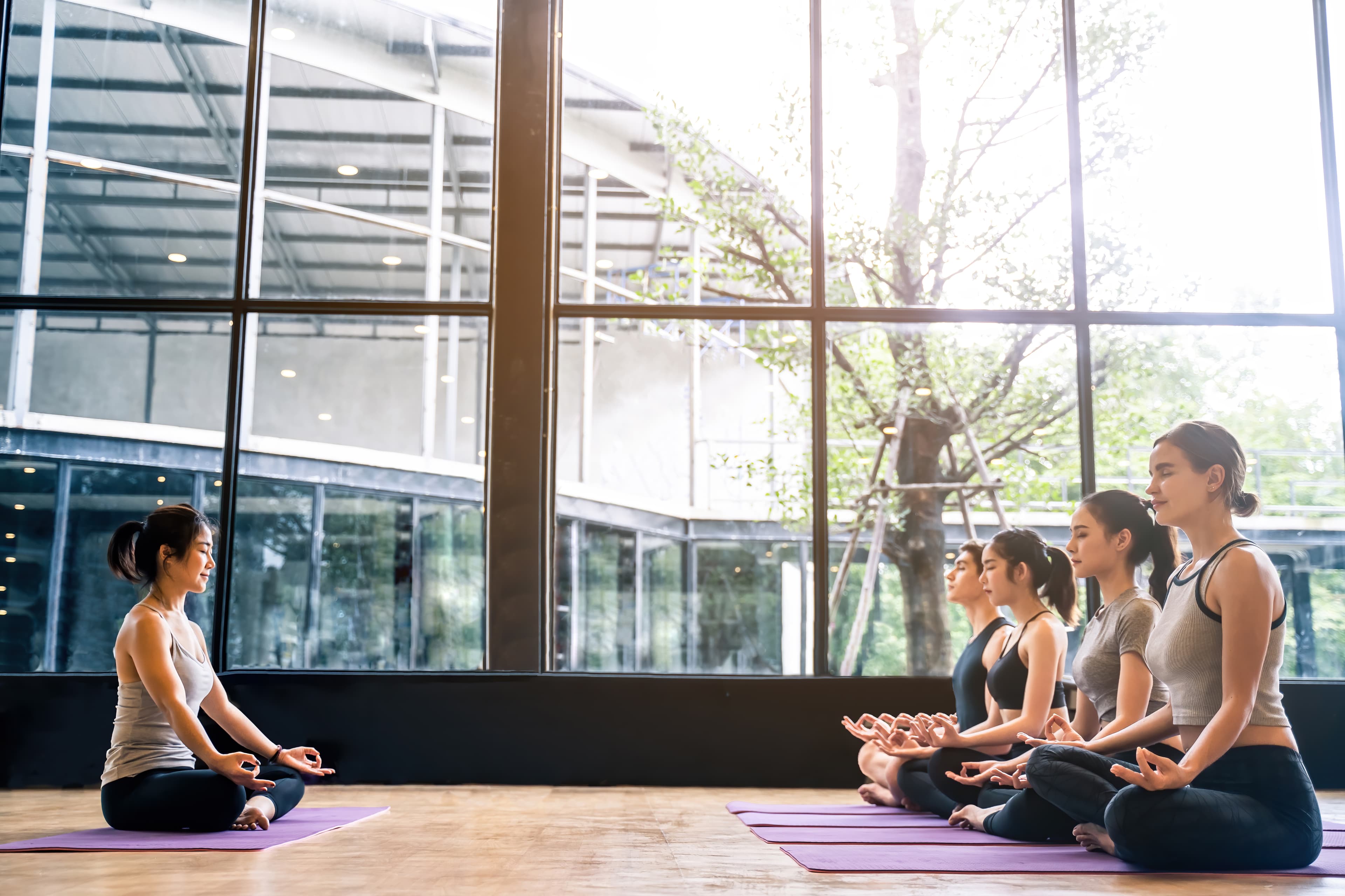 Group practicing meditation together in a bright studio
